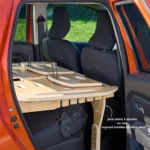 Mobikit Box dépliée en lit deux places dans le coffre d'un SUV 